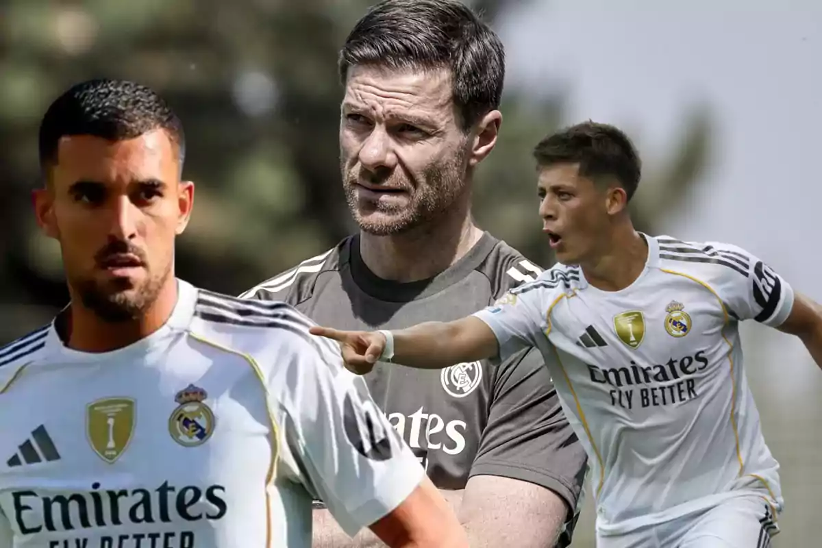 Tres personas relacionadas con el Real Madrid, dos jugadores con uniforme blanco y un entrenador al centro con camiseta gris, en un entorno al aire libre.