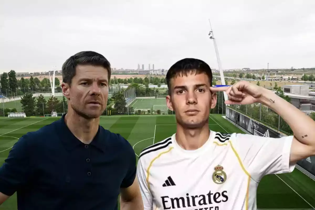 Two people in the foreground on a soccer training field, one of them wearing a white Real Madrid jersey and making a gesture with their hand on their head.