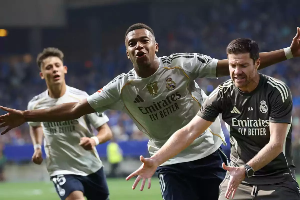 Real Madrid players and coach celebrate a goal during a soccer match in a stadium full of fans.