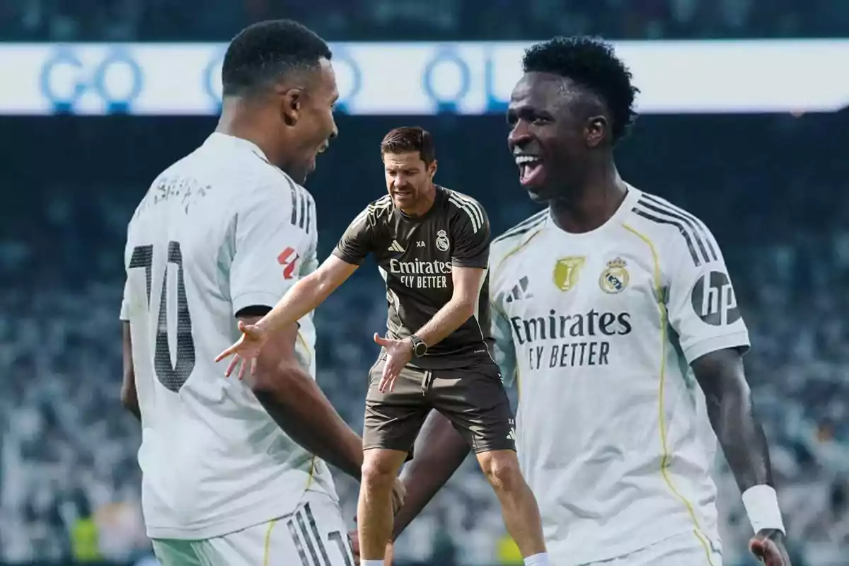 Soccer coach giving instructions to two Real Madrid players celebrating on the field