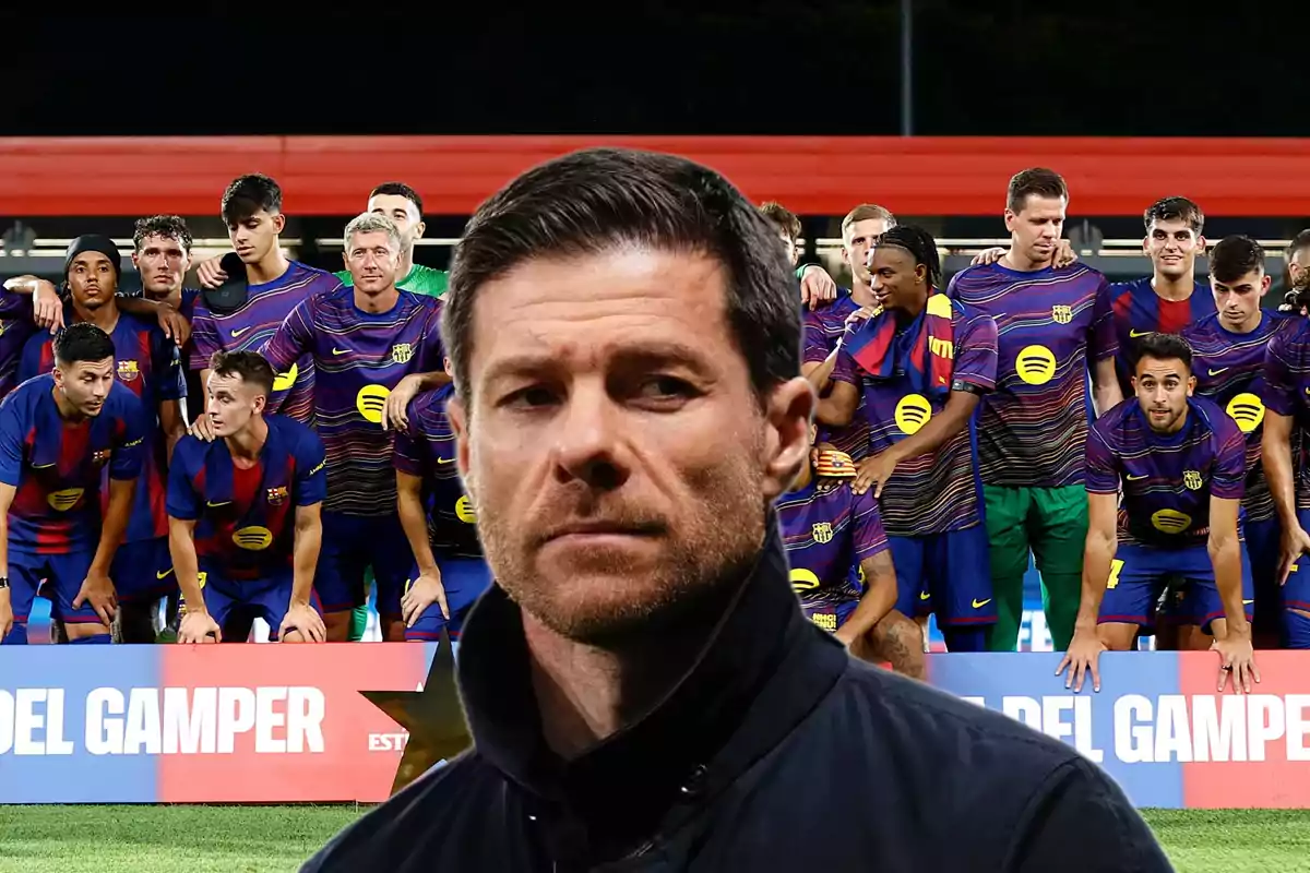 A man in the foreground with a serious expression and, in the background, a soccer team posing for a group photo in a stadium
