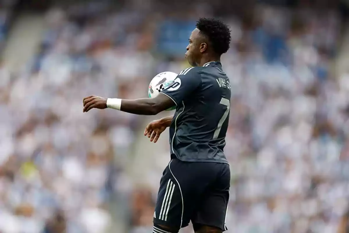 Soccer player in a dark uniform controls the ball with his chest during a match Soccer player in a dark uniform controls the ball with his chest during a match