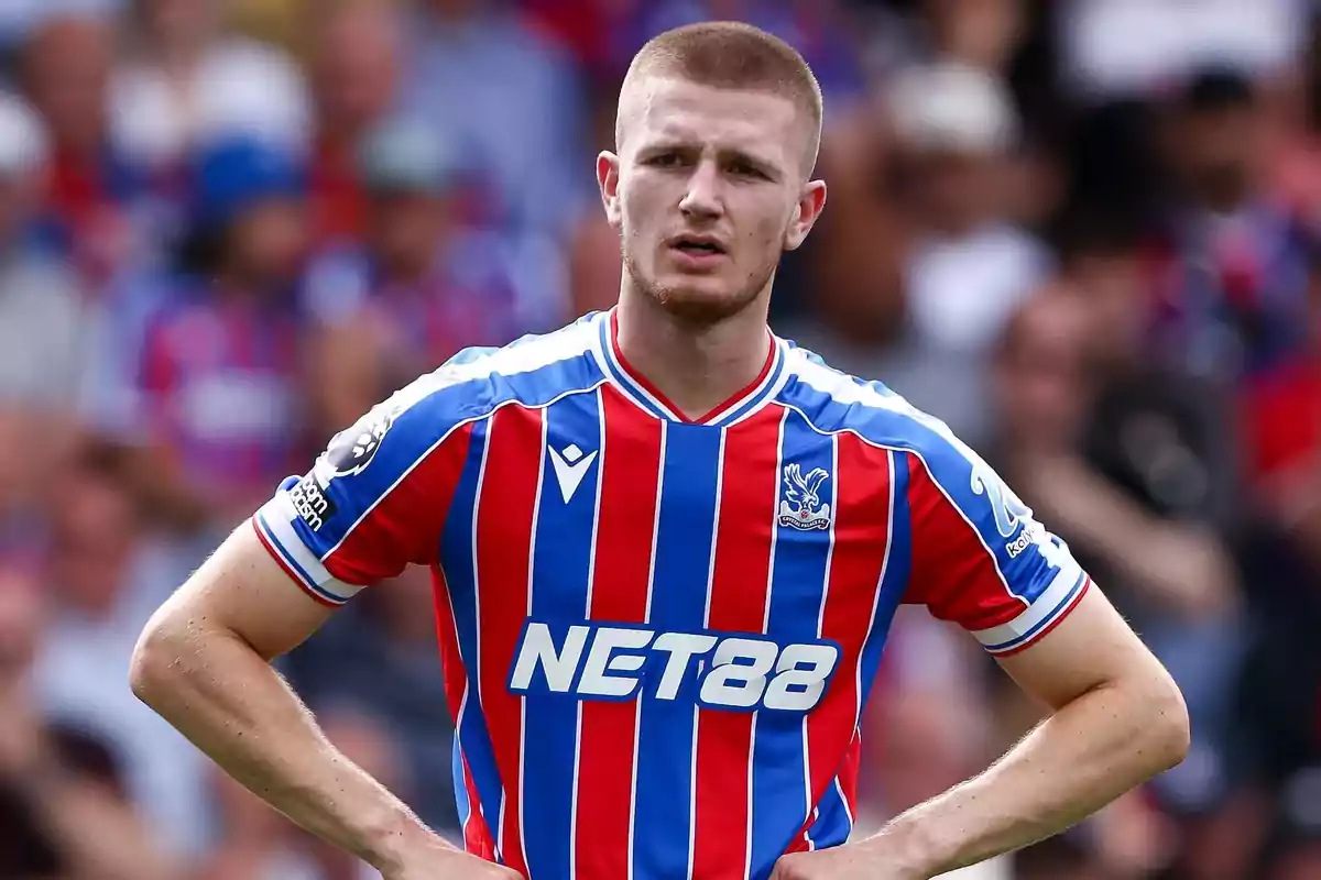 Soccer player wearing Crystal Palace’s red and blue striped uniform on the field during a match Soccer player wearing Crystal Palace’s red and blue striped uniform on the field during a match