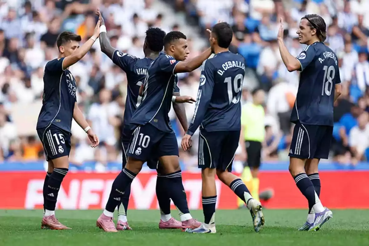 Real Madrid players celebrate together on the field during a match Real Madrid players celebrate together on the field during a match