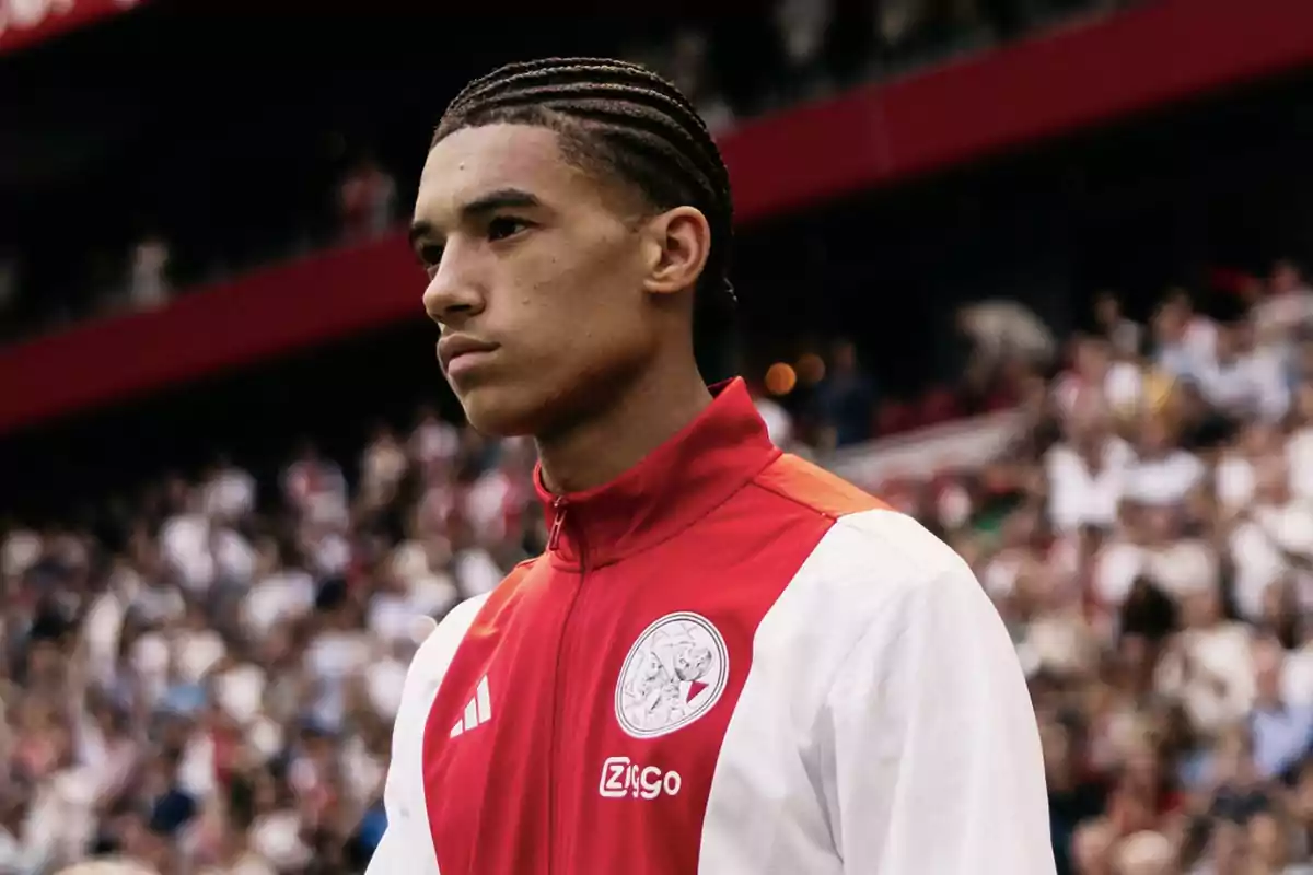 Young player wearing an Ajax jacket in a stadium full of spectators Young player wearing an Ajax jacket in a stadium full of spectators