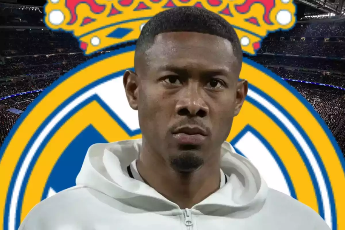 Jugador de fútbol con sudadera blanca frente al escudo del Real Madrid en un estadio lleno de espectadores