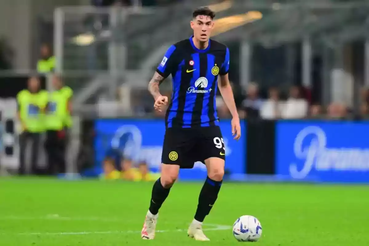 Futbolista con uniforme negro y azul del Inter de Milán controla el balón en un partido Futbolista con uniforme negro y azul del Inter de Milán controla el balón en un partido