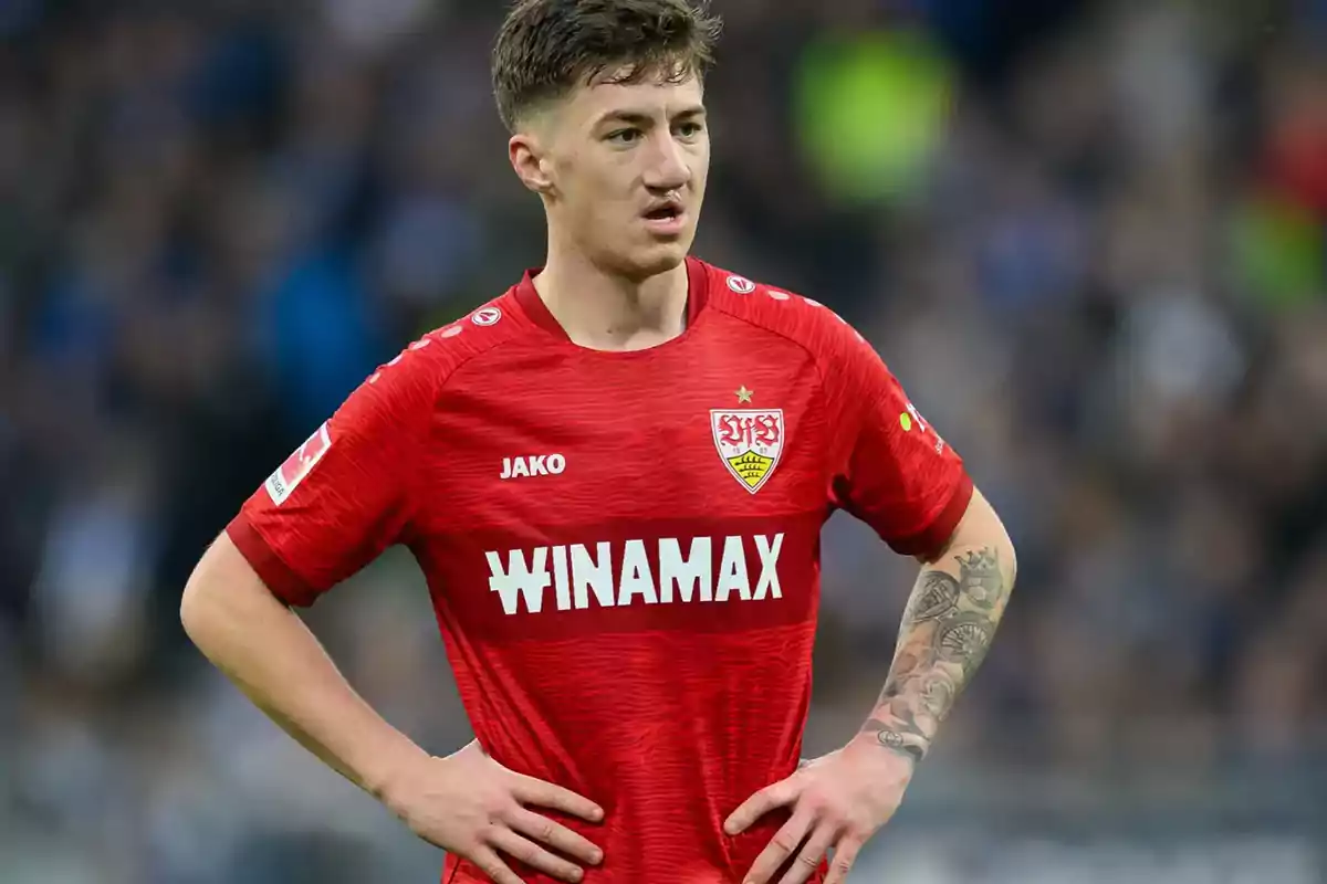 Soccer player in a red Stuttgart uniform on the field with hands on hips Soccer player in a red Stuttgart uniform on the field with hands on hips