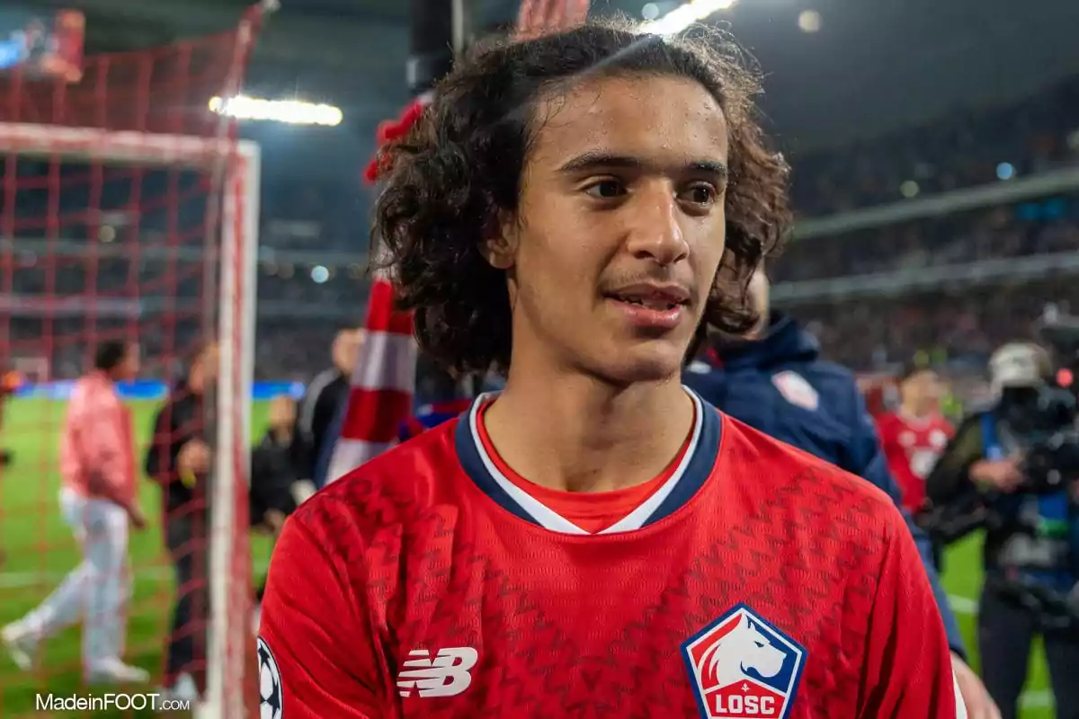 Young footballer wearing a red LOSC Lille jersey in a stadium during a match