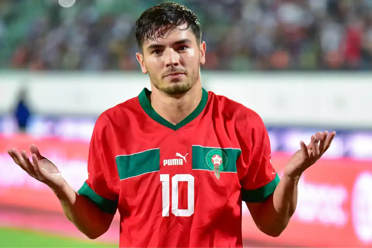 Futbolista con camiseta roja de Marruecos haciendo un gesto de encogerse de hombros en el campo Futbolista con camiseta roja de Marruecos haciendo un gesto de encogerse de hombros en el campo
