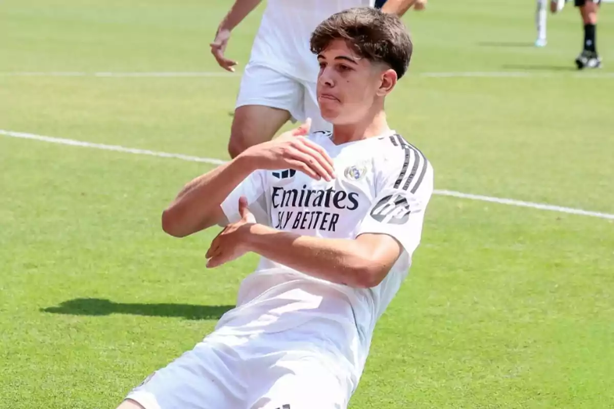 Young player celebrating a goal on the field wearing Real Madrid’s white uniform Young player celebrating a goal on the field wearing Real Madrid’s white uniform