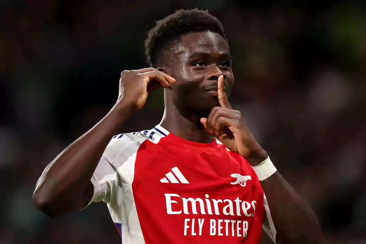 Arsenal footballer celebrating a goal with a silence gesture in the stadium Arsenal footballer celebrating a goal with a silence gesture in the stadium