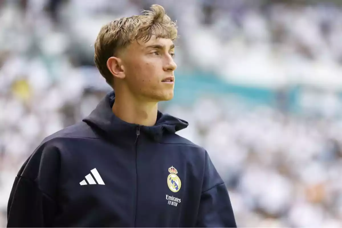 Joven futbolista con chaqueta del Real Madrid en un estadio