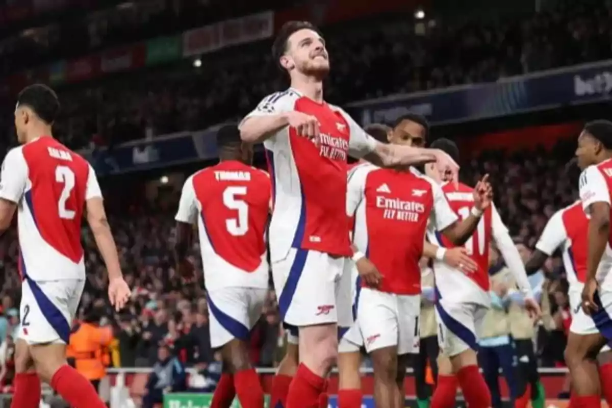 Arsenal players celebrate a goal in a packed stadium during a soccer match. Arsenal players celebrate a goal in a packed stadium during a soccer match.