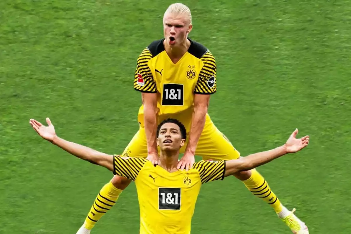 Dos jugadores del Borussia Dortmund celebran un gol en el campo, uno de ellos está de pie detrás del otro con los brazos sobre sus hombros y ambos visten uniforme amarillo Dos jugadores del Borussia Dortmund celebran un gol en el campo, uno de ellos está de pie detrás del otro con los brazos sobre sus hombros y ambos visten uniforme amarillo