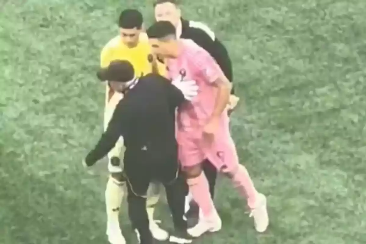 Jugadores de fútbol discuten en el campo mientras los árbitros intentan separarlos Jugadores de fútbol discuten en el campo mientras los árbitros intentan separarlos