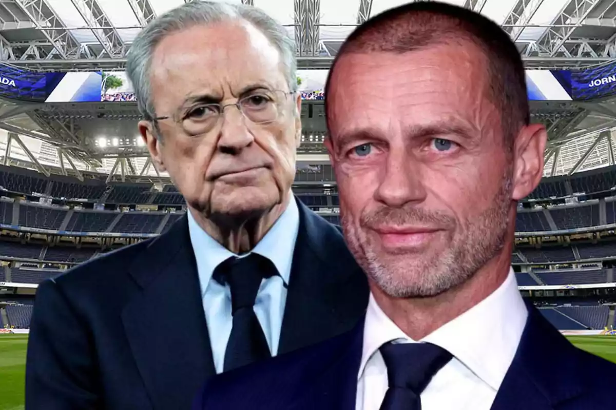 Two men in suits pose inside a modern soccer stadium.