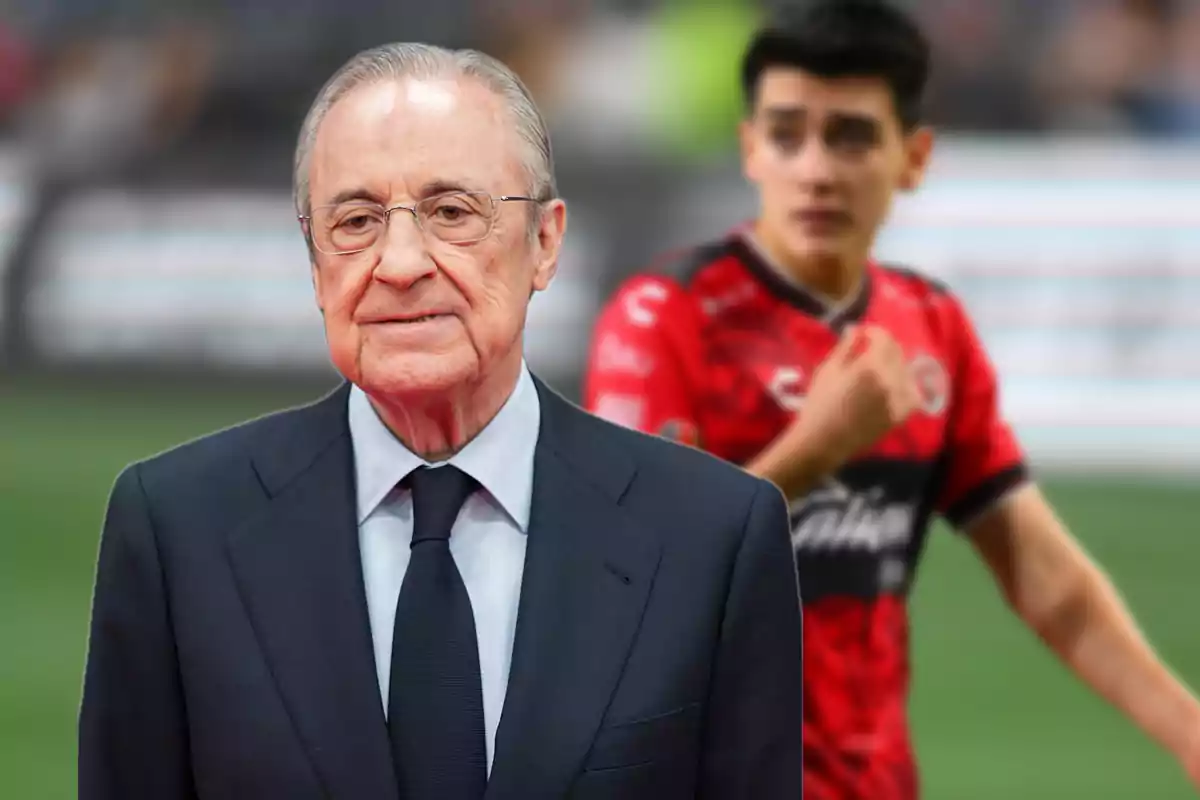 Older man with glasses and a dark suit in the foreground with a player in the background at a stadium