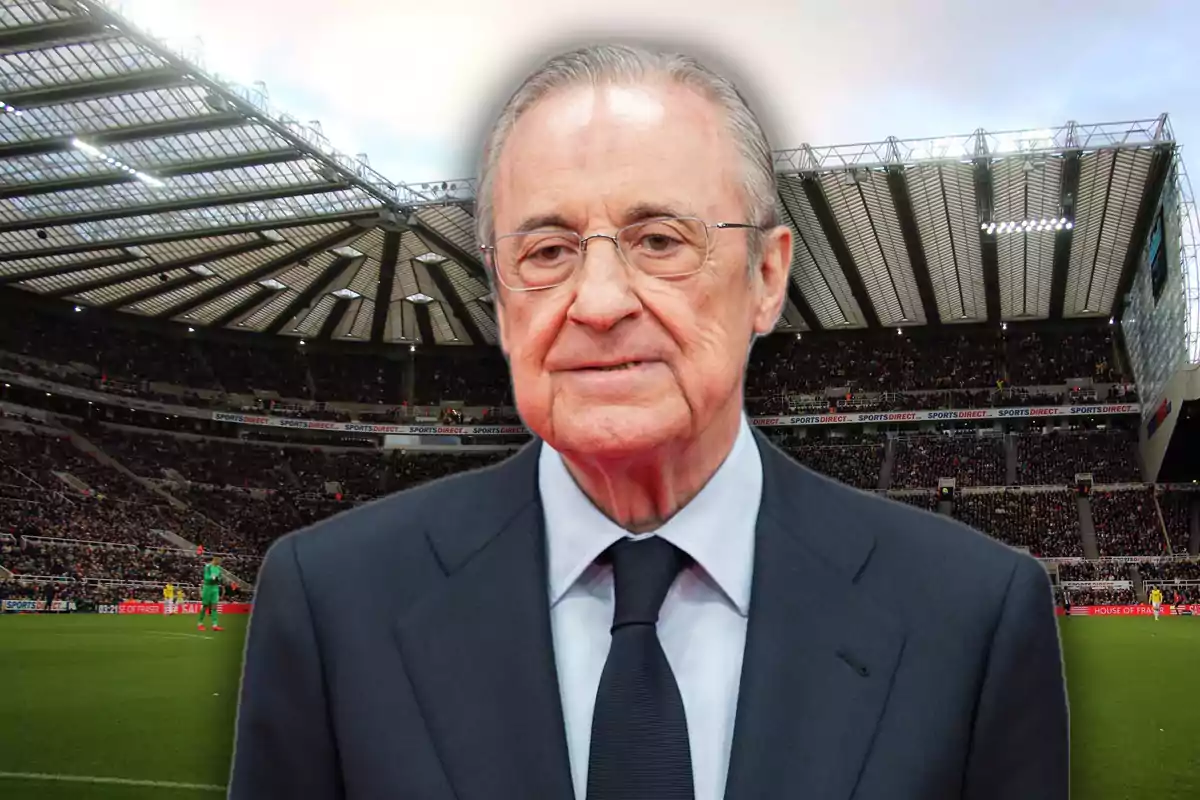 Older man with glasses and a dark suit in the center of a football stadium full of spectators