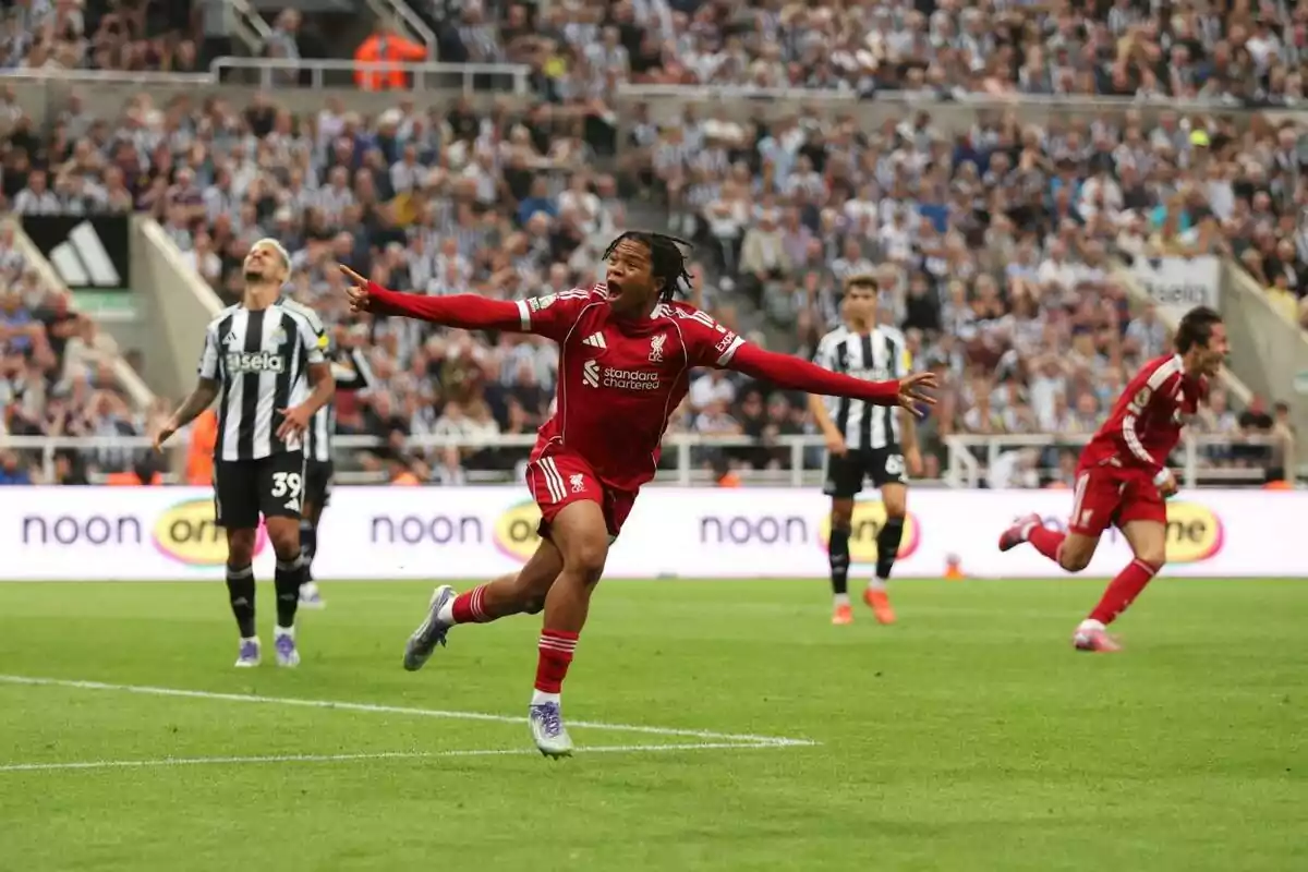 Liverpool footballer celebrating a goal while Newcastle players watch in the stadium full of fans Liverpool footballer celebrating a goal while Newcastle players watch in the stadium full of fans