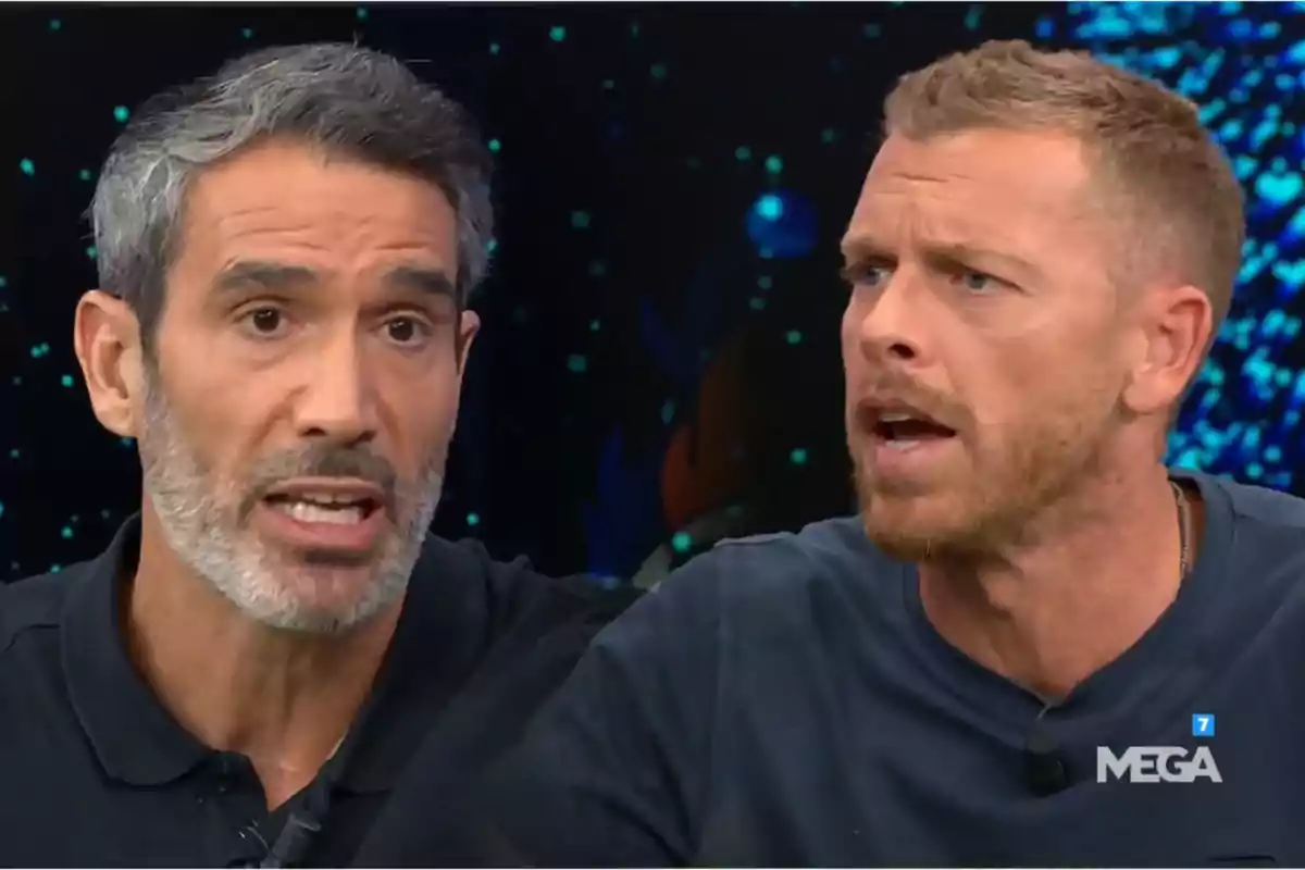 Two men argue on a television set with a dark background and the Mega logo in the bottom right corner.
