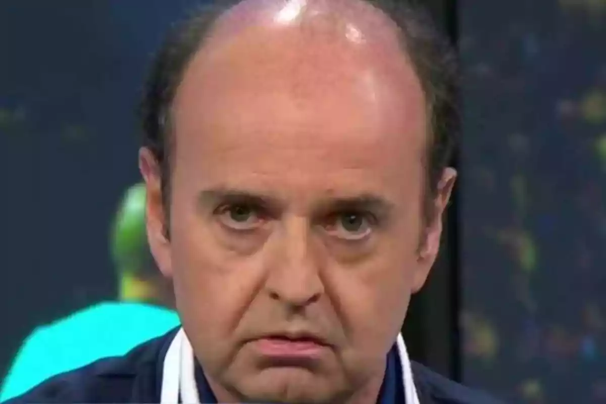 Hombre calvo con expresión seria mirando al frente