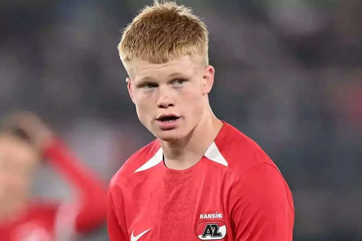 Young footballer wearing a red AZ Alkmaar jersey during a match Young footballer wearing a red AZ Alkmaar jersey during a match