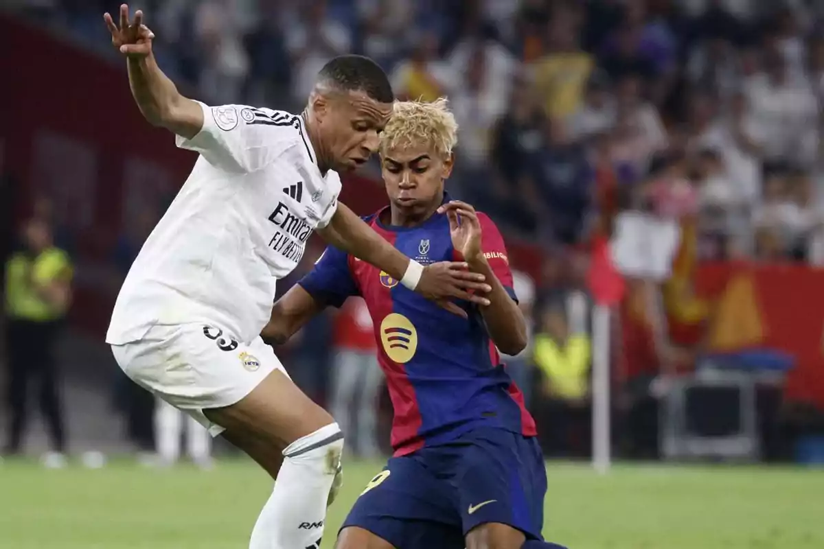 Two players from the teams Real Madrid and Barcelona compete for the ball during a match in a stadium full of spectators. Two players from the teams Real Madrid and Barcelona compete for the ball during a match in a stadium full of spectators.