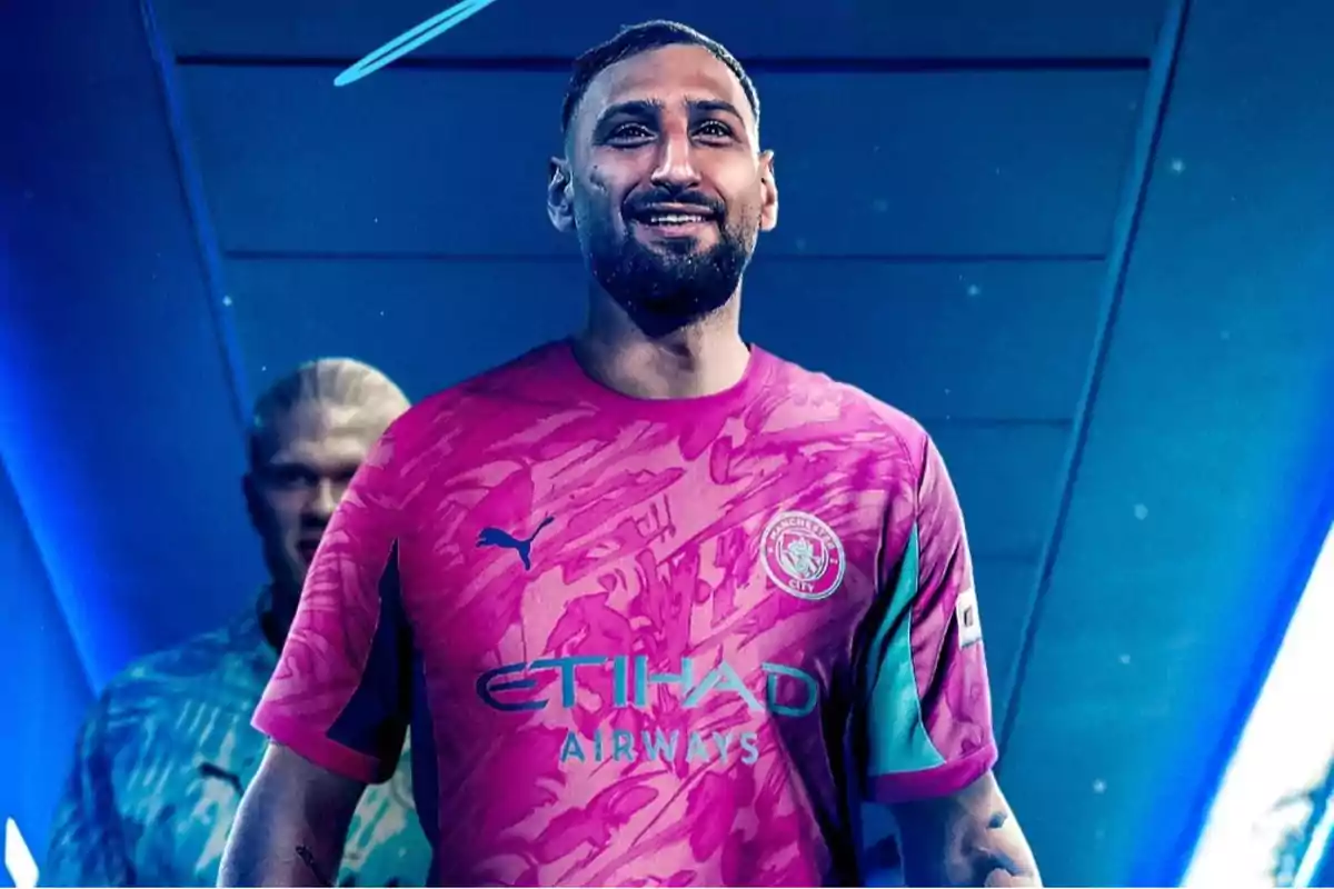 Un futbolista sonriente con la camiseta rosa del Manchester City y fondo azul Un futbolista sonriente con la camiseta rosa del Manchester City y fondo azul