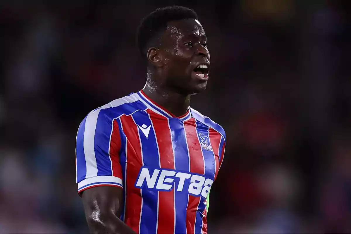 Soccer player in a red and blue striped uniform during a match Soccer player in a red and blue striped uniform during a match