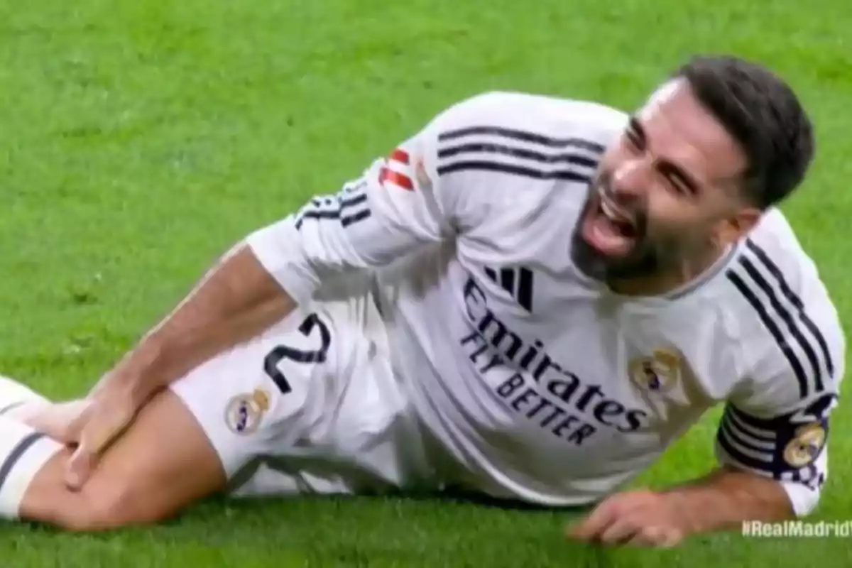 Real Madrid player lying on the grass with a pained expression, holding his leg Real Madrid player lying on the grass with a pained expression, holding his leg
