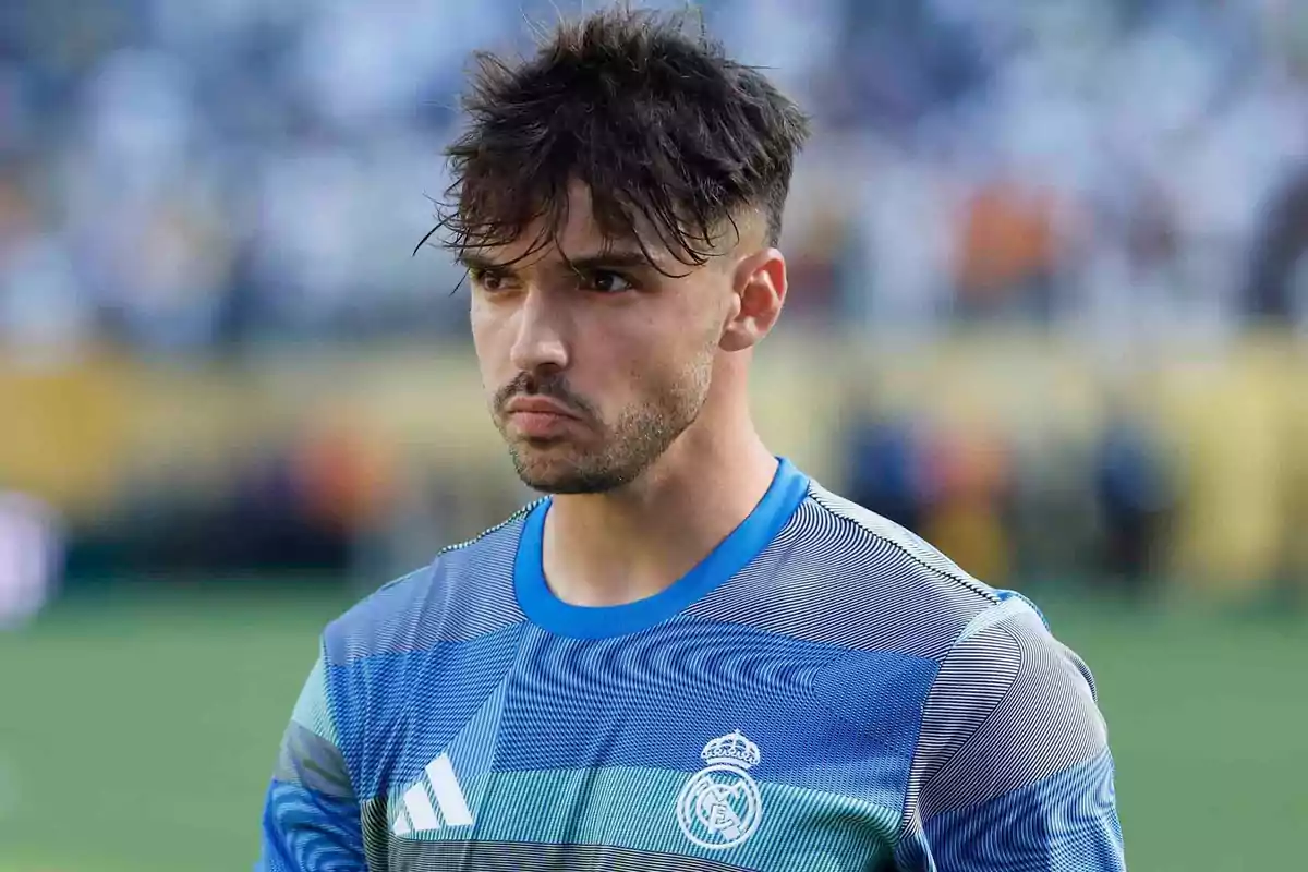 Soccer player wearing a Real Madrid training jersey on a playing field Soccer player wearing a Real Madrid training jersey on a playing field