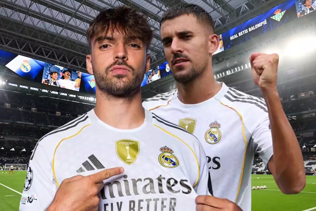 Two players in Real Madrid uniforms pose in a stadium full of fans; one points to the team’s crest and the other raises his fist in celebration.