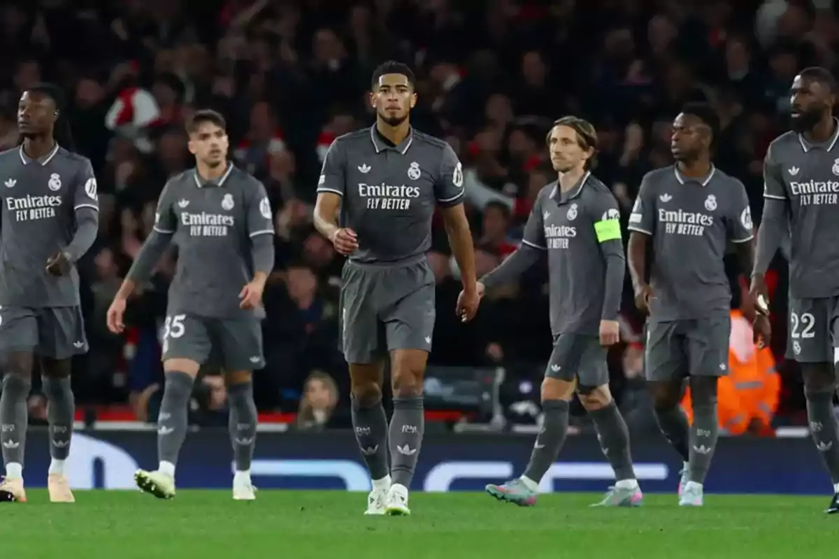 Real Madrid players in gray uniforms walking on the field during a soccer match