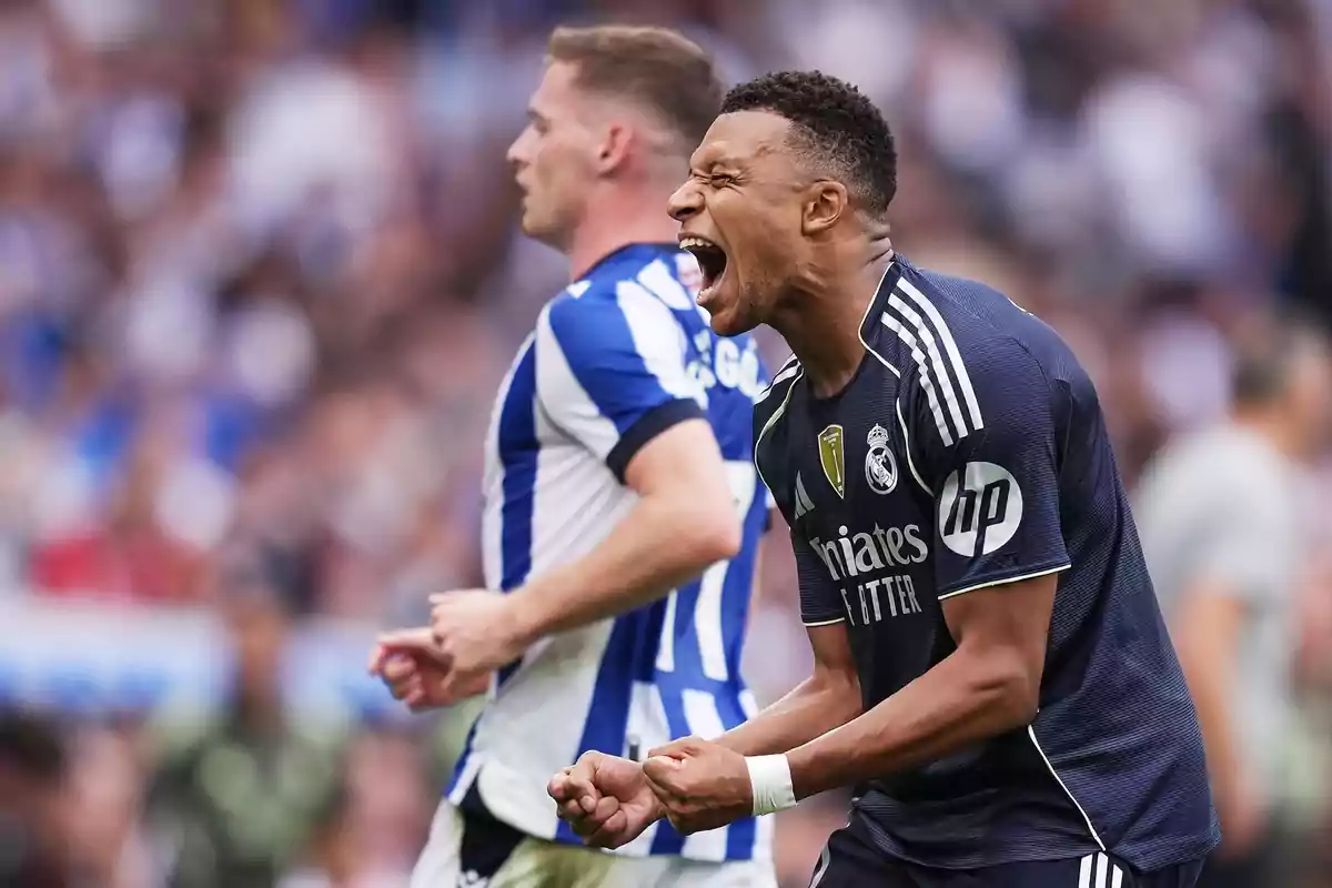 Real Madrid player celebrating effusively during a match while a Real Sociedad opponent appears in the background