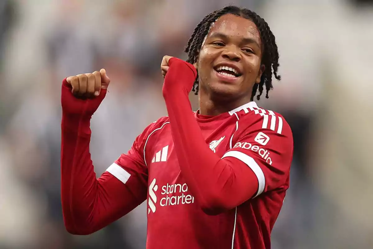 Soccer player in a red uniform celebrating on the field with a big smile Soccer player in a red uniform celebrating on the field with a big smile