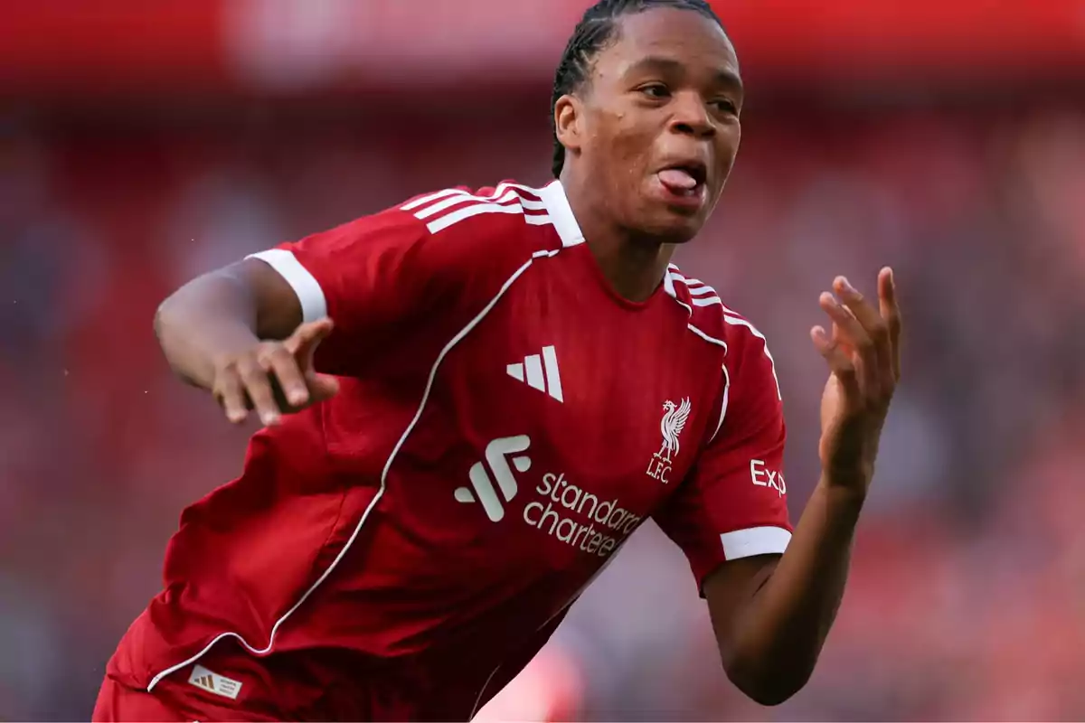 Liverpool player celebrating a goal in the red uniform and sticking out his tongue during a match Liverpool player celebrating a goal in the red uniform and sticking out his tongue during a match