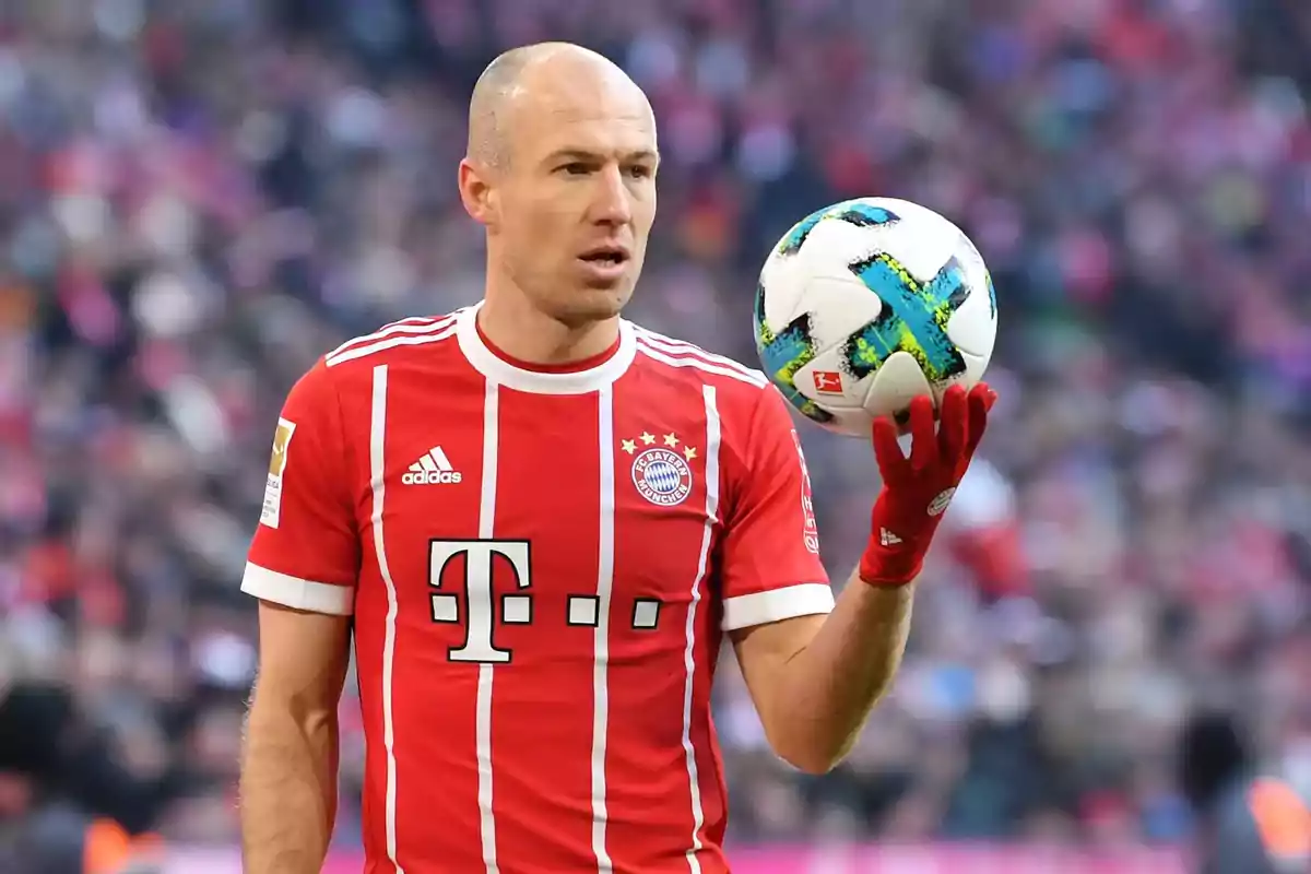 Soccer player in a red Bayern Munich uniform holding a ball in his hand during a match Soccer player in a red Bayern Munich uniform holding a ball in his hand during a match