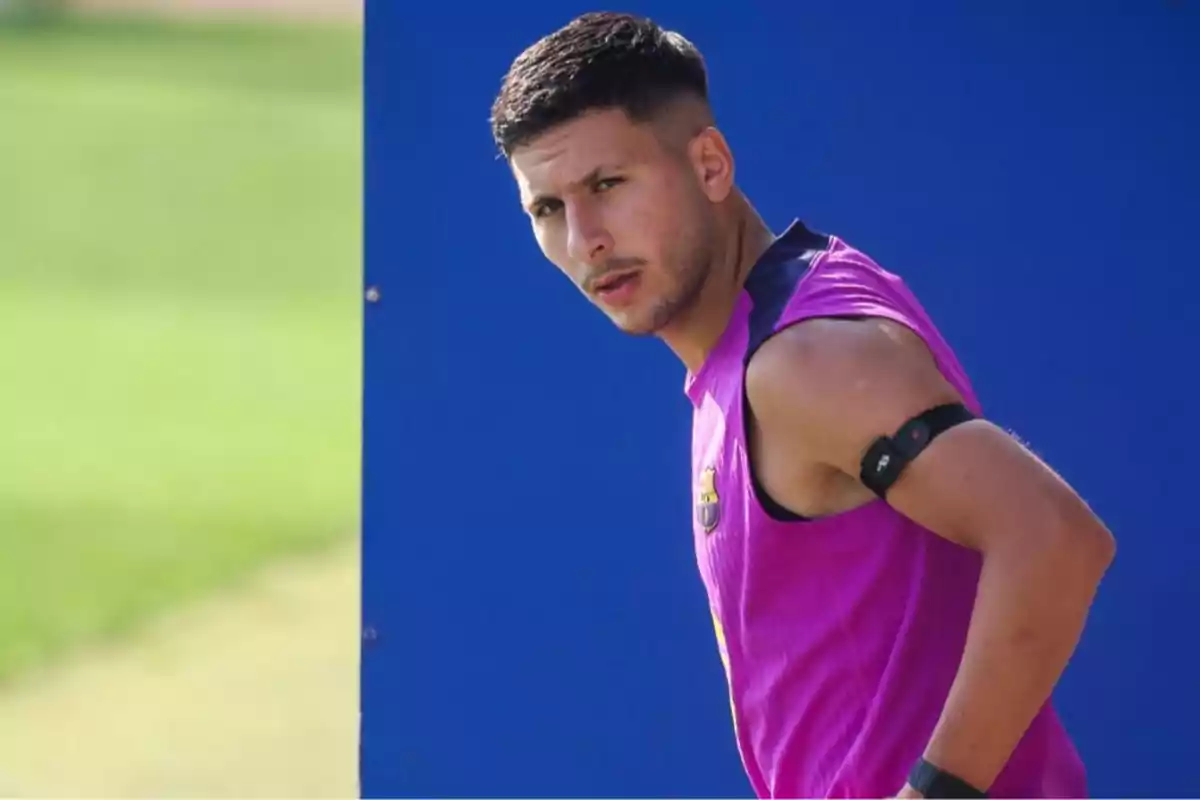 Young athlete wearing a pink sleeveless jersey and an armband during an outdoor workout Young athlete wearing a pink sleeveless jersey and an armband during an outdoor workout