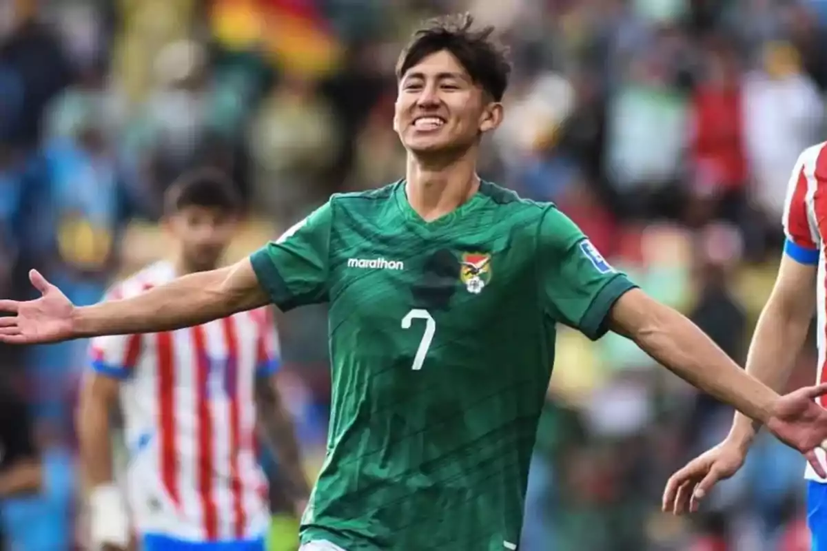 Soccer player wearing a green Bolivia jersey celebrating a goal with arms outstretched during a match Soccer player wearing a green Bolivia jersey celebrating a goal with arms outstretched during a match