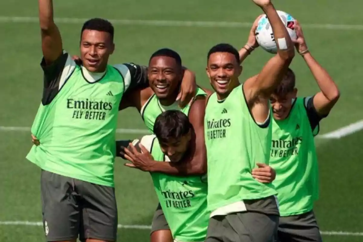 Cinco futbolistas sonríen y posan juntos en un campo de entrenamiento usando petos verdes del Real Madrid Cinco futbolistas sonríen y posan juntos en un campo de entrenamiento usando petos verdes del Real Madrid