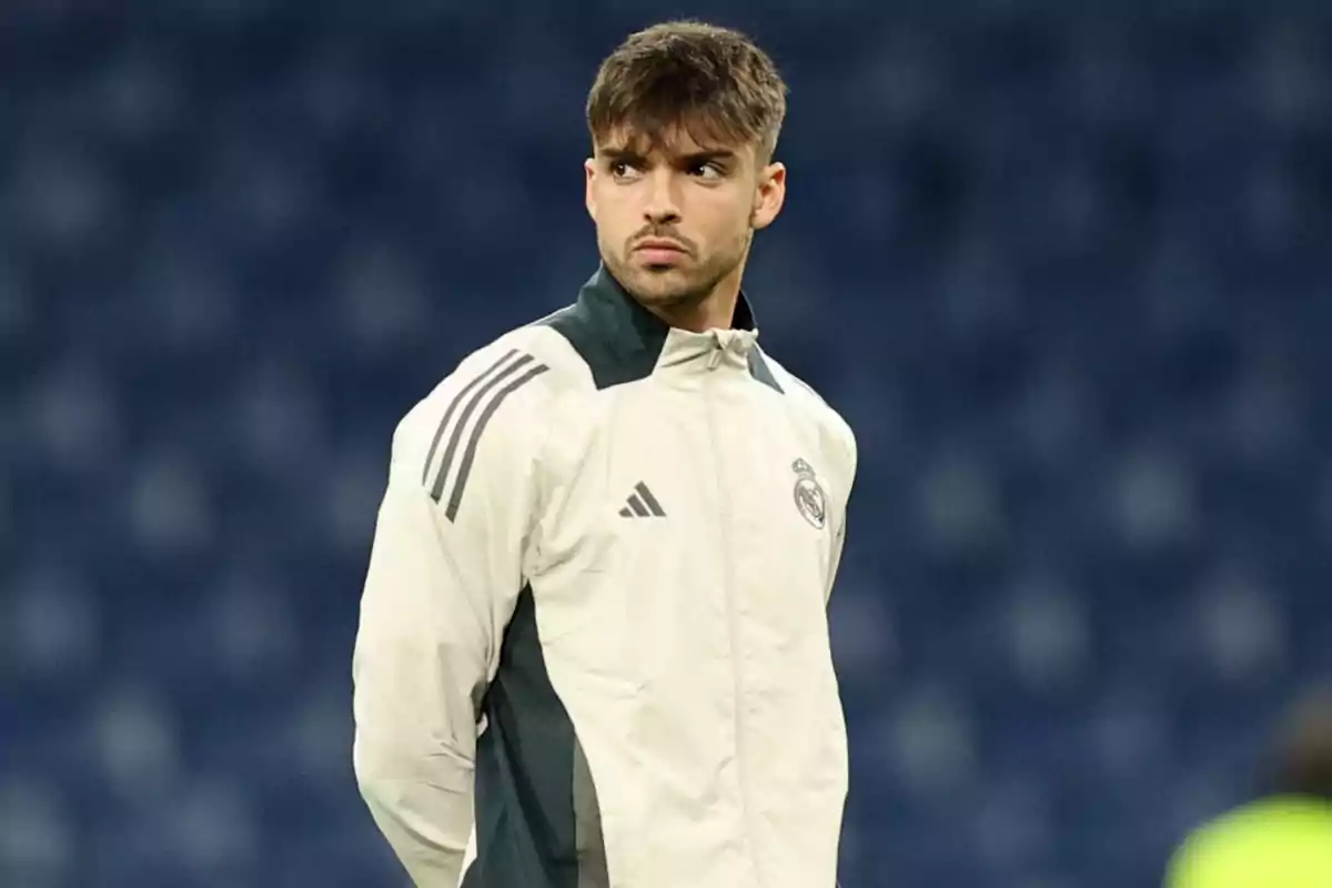 Young player wearing a white Real Madrid training jacket in a stadium