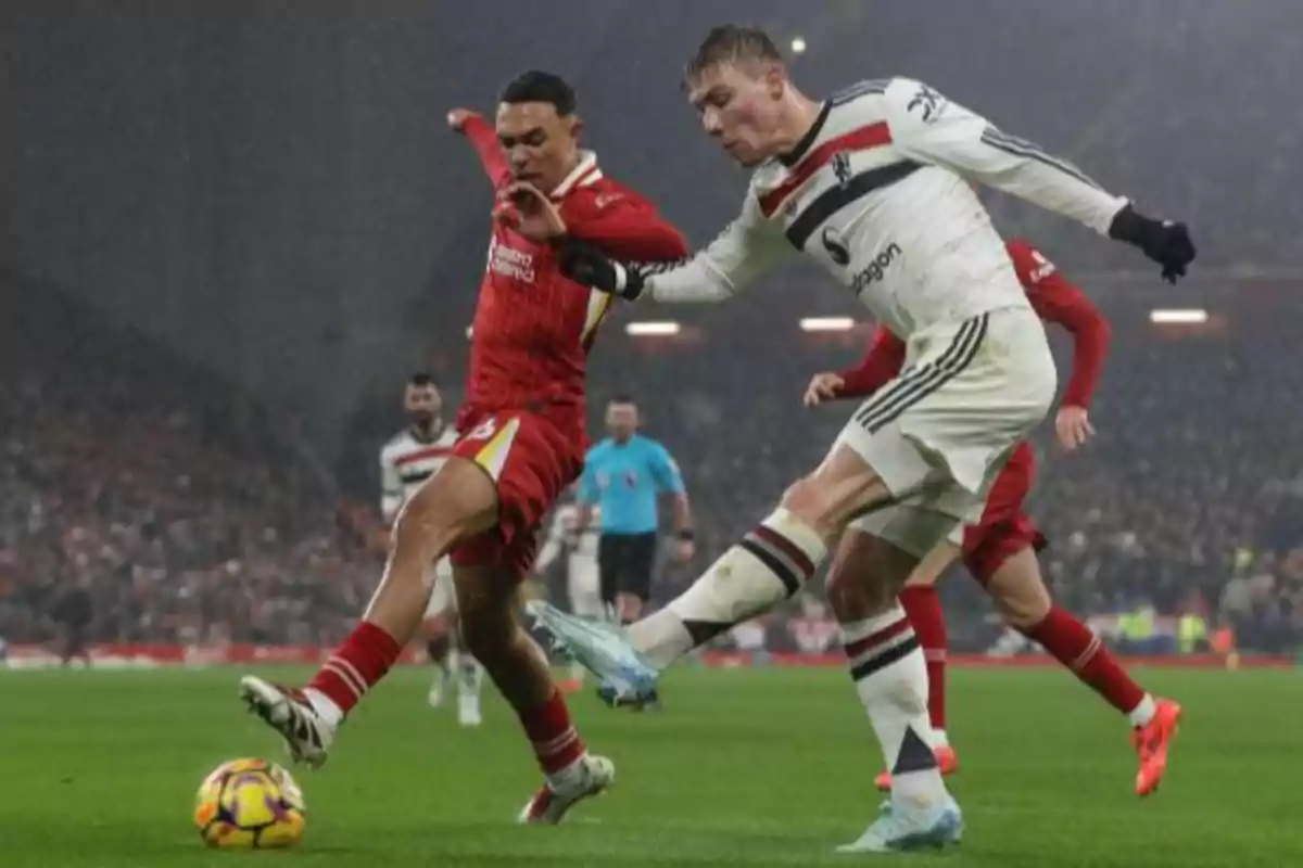 Two soccer players compete for the ball in a game under the rain. Two soccer players compete for the ball in a game under the rain.