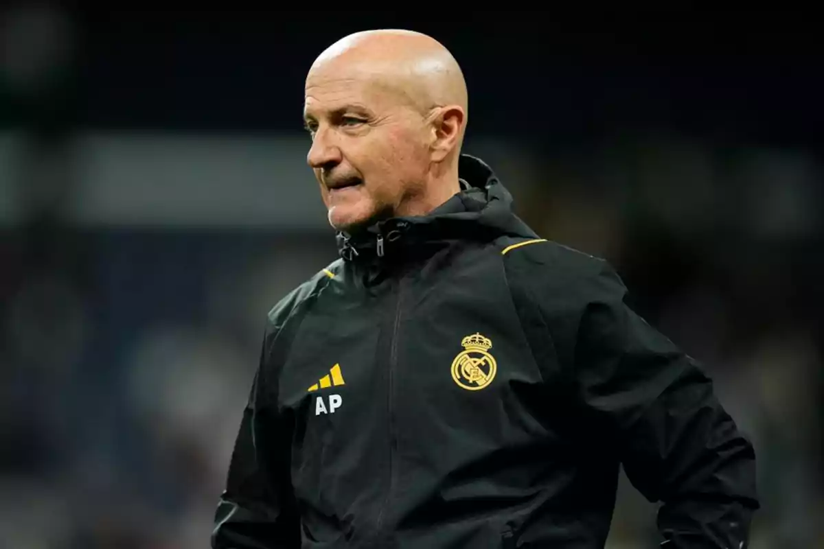 A bald man with a black Real Madrid jacket and the initials AP.