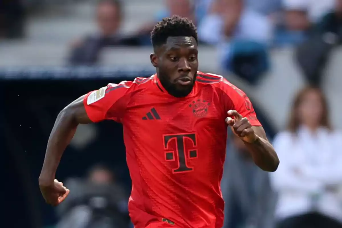 Jugador de fútbol corriendo en el campo con el uniforme rojo del Bayern de Múnich.