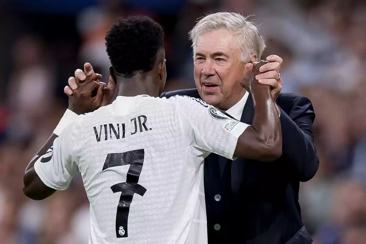 A soccer player wearing the number 7 jersey interacts with a man in a suit on a playing field.