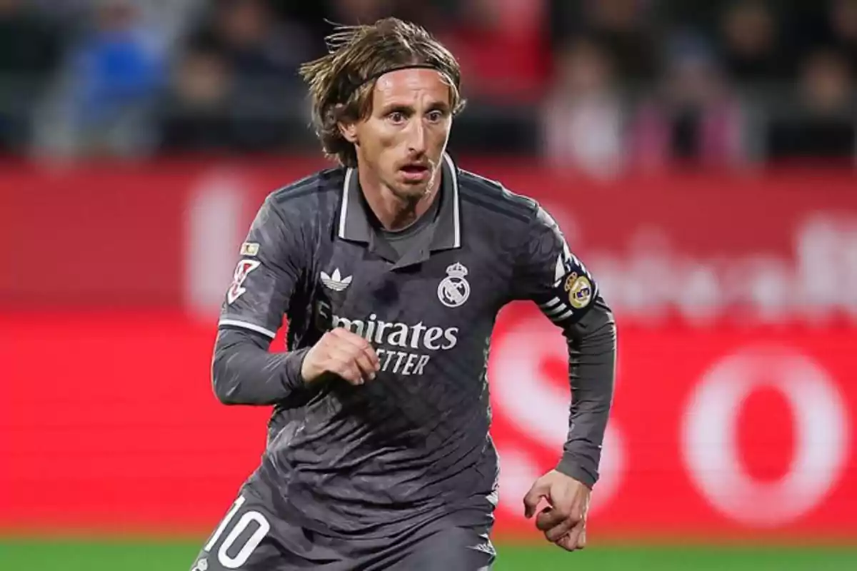 Football player in grey Real Madrid uniform in action during a match.