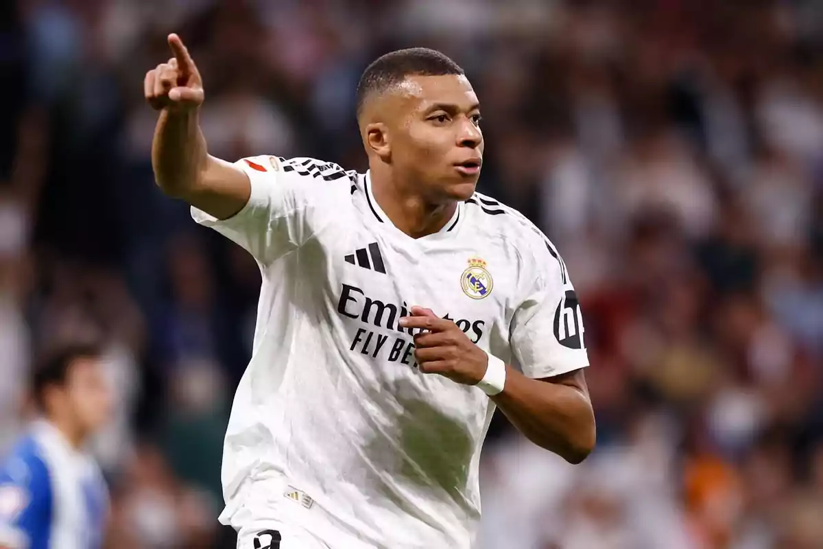 A soccer player in a white uniform celebrates a goal on the field.