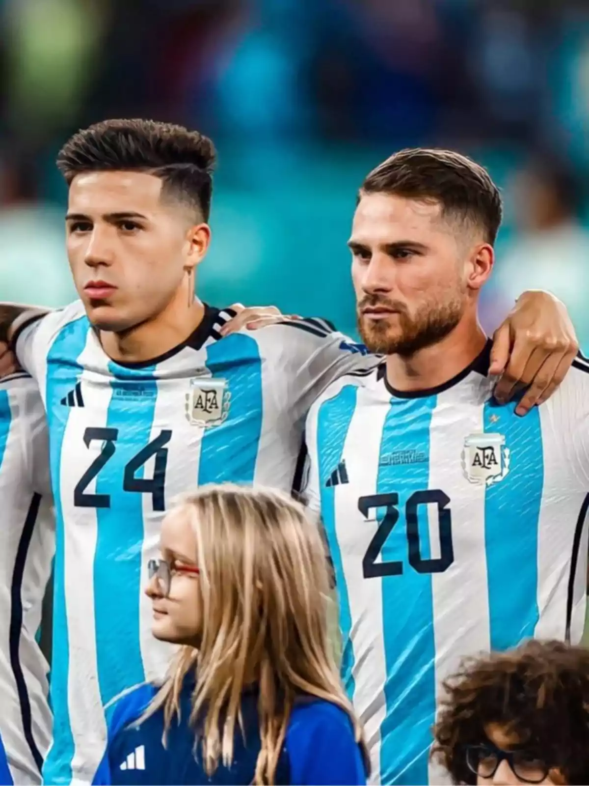 Soccer players wearing Argentina jerseys pose together on the field before a match, with children in front. Soccer players wearing Argentina jerseys pose together on the field before a match, with children in front.