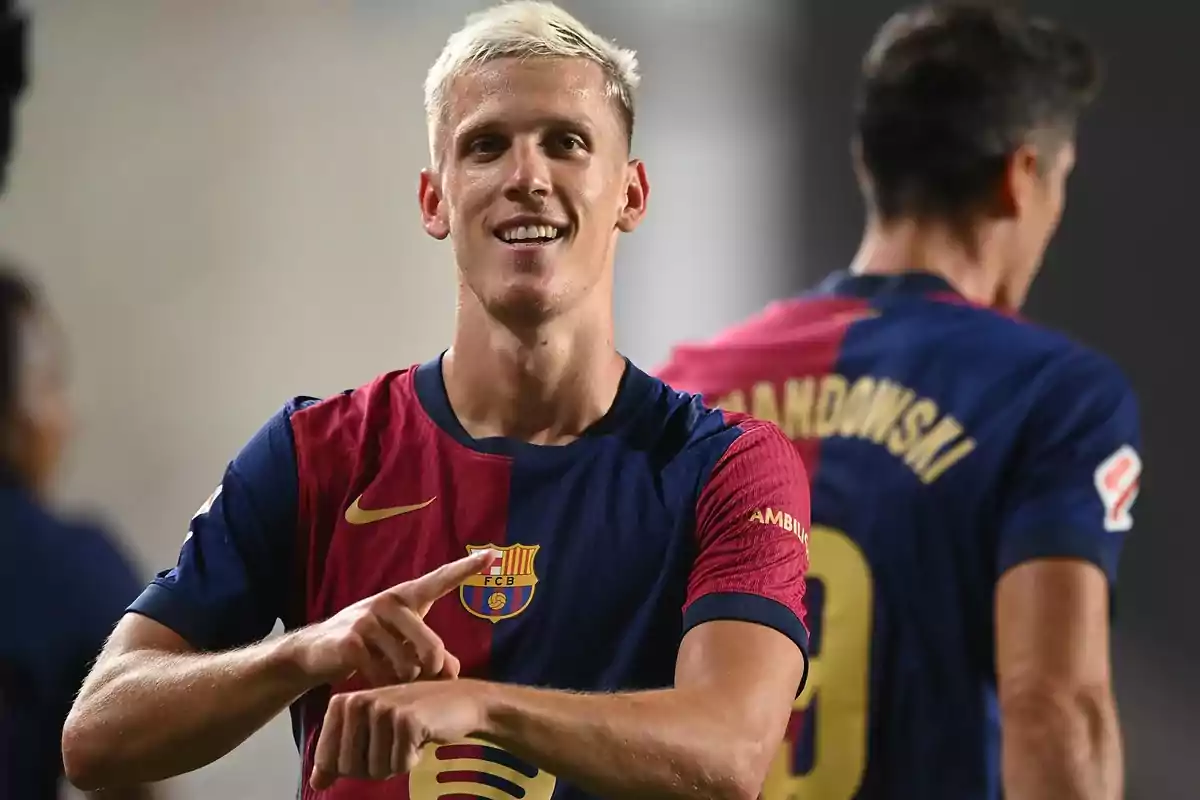 Football player in FC Barcelona uniform celebrating on the field.